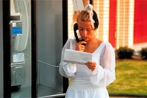 A 1991 Boston Crusaders color guard member makes a call on a nearby pay phone.